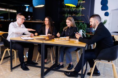 Genç tasarımcılar öğle yemeğinde ortaklarıyla yeni proje fikirlerini tartışıyor. İşadamları ofiste yeni bir iş projesini tartışıyorlar..