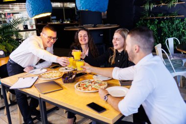 Genç tasarımcılar öğle yemeğinde ortaklarıyla yeni proje fikirlerini tartışıyor. İşadamları ofiste yeni bir iş projesini tartışıyorlar..