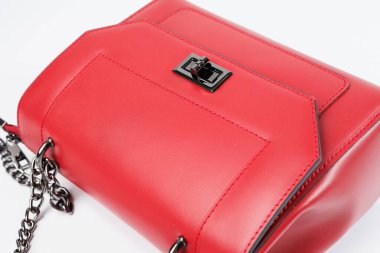 Beyaz izole bir arka planda bronz işlemeli yeni kadın kırmızı çantası. Yeni deri çanta koleksiyonu