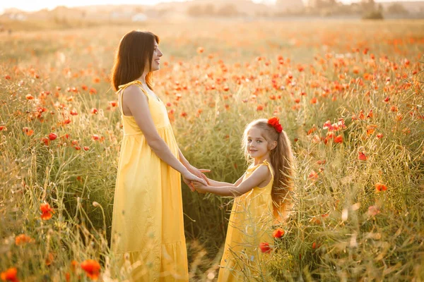Young Pregnant Woman Her Daughter Yellow Dresses Standing Poppy Field — Stock Photo, Image