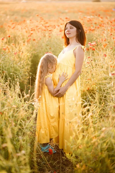 Mladá Těhotná Žena Svou Dcerou Žlutých Šatech Stojí Makovém Poli — Stock fotografie