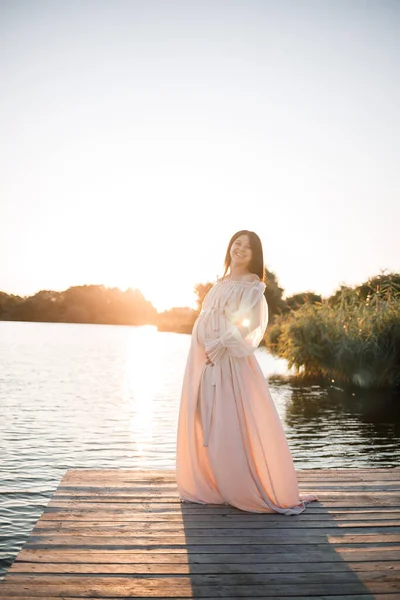 Uma Jovem Grávida Vestido Chiffon Fica Cais Junto Rio Contra — Fotografia de Stock