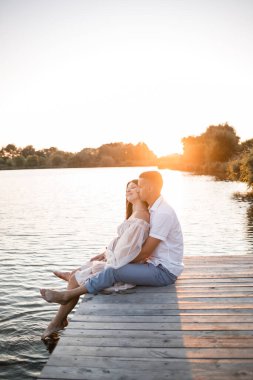Hamile bir eşi olan bir koca, gün batımında güneşli yaz günbatımında bir rıhtımda dinleniyor. Birbirine aşık çiftler. Sarılıyorlar, el ele tutuşuyorlar.,