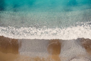 Gök mavisi suyu ve kumlu plajı olan deniz manzarası. Kıyı şeridi ile Orta Yeryüzü 'nün havadan görünüşü. Yaz mevsiminde insansız hava aracından çekilen güzel tropikal deniz.