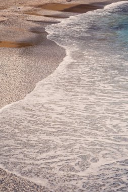 Akdeniz sahilinde gök mavisi su dalgaları var. Yaz deniz esintisi. Güneşli havada deniz kıyısında. Seçici odak
