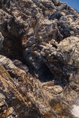 Mavi Akdeniz 'in harika manzarası. Güneşli kayalar, köpüklü dalgalar ve su sıçraması. Dalga kıyıdaki kayalara çarpar.