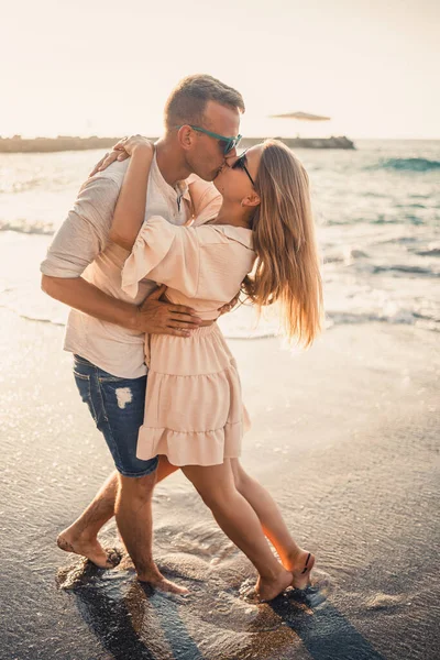 Birbirine aşık bir çift deniz kenarında sahilde yürüyor. Akdeniz kıyısında gün batımında genç bir aile. Yaz tatili kavramı