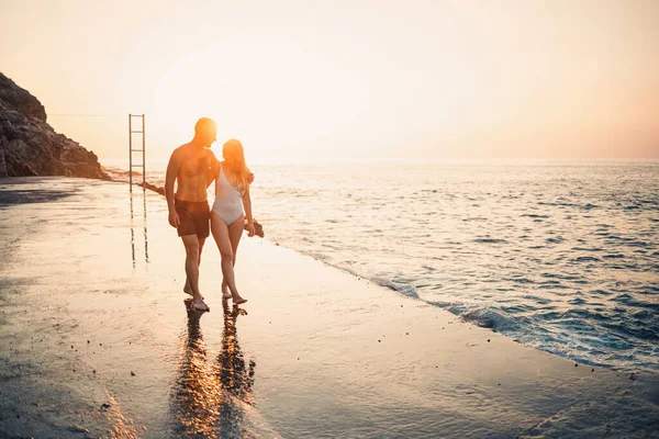 地中海のビーチに沿って日没で一緒に歩くのが大好きロマンチックな若いカップル 暖かい国での夏休み 幸せな夫婦はトルコで休暇中です 選択的焦点 — ストック写真