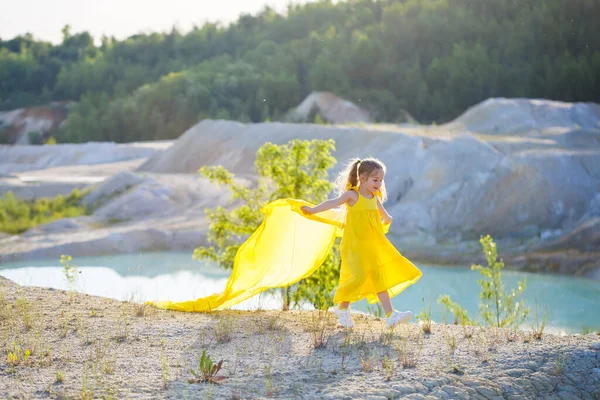 Ukraynalı 7 yaşında, Ukraynalı bir vatansever, mavi gökyüzüne karşı sarı bir elbise giymiş. Mavi gökyüzü. Güneşli bir gün. Özgür Ukraynalı çocuk. Ukrayna 'nın çocuk sembolü