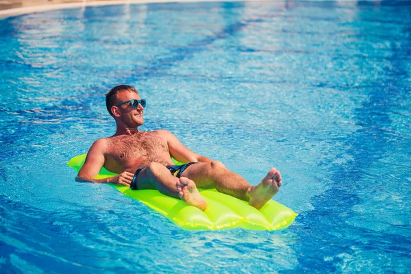 Ein Junger Mann Badet Pool Auf Einer Gelben Aufblasbaren Matratze — Stockfoto