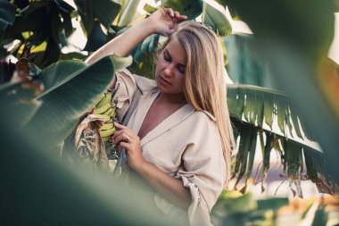 Yeşil muz yaprakları yakınında egzotik tropikal bir kadın. Tropik ada kızı tatilde.