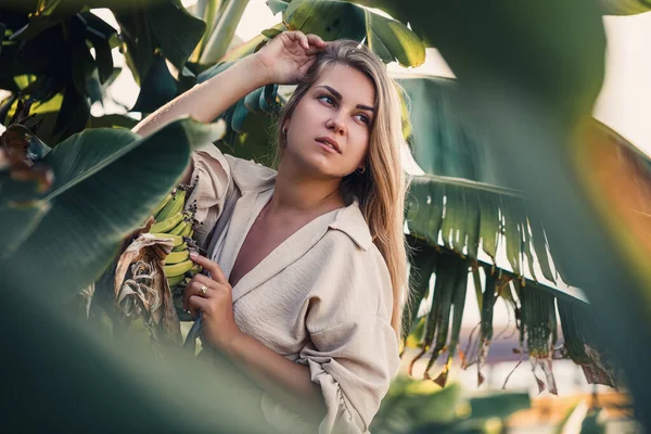 Yeşil muz yaprakları yakınında egzotik tropikal bir kadın. Tropik ada kızı tatilde.