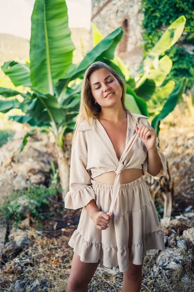 熱帯公園のバナナの木の近くに立つ魅力的な若い色白の女性 — ストック写真
