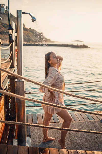 海に沈む夕日の光の中で完璧な姿をした美しい若い女性 休暇で黄金の日焼けした少女 選択的焦点 — ストック写真