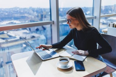 Kafeteryada bilgisayar ve kahve fotokopi alanı kullanarak çalışan mutlu Avrupalı kadın. Başarılı bayan serbest yazar dizüstü bilgisayarda yazıyor, uzaktan çalışıyor.