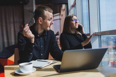 Bir iş projesinde birlikte çalışıyoruz. İki genç iş arkadaşı, modern büyük bir ofiste dizüstü bilgisayarda çalışıyor. İş yerindeki iş ortakları