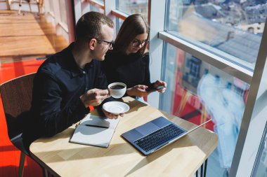 Mutlu iş adamları masada oturuyor, konuşuyor, gülüyor, iş belgelerini tartışıyor, gülümsüyor, iş arkadaşları bir brifingde iş birliği yapıyor, bir toplantıda beyin fırtınası yapıyorlar.