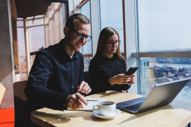 Mutlu iş adamları masada oturuyor, konuşuyor, gülüyor, iş belgelerini tartışıyor, gülümsüyor, iş arkadaşları bir brifingde iş birliği yapıyor, bir toplantıda beyin fırtınası yapıyorlar.