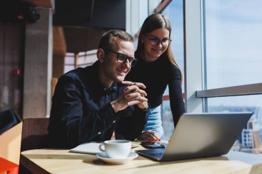 Başarılı iş ekibi, iş yerinde konuşan erkek ve kadın meslektaşlar, dizüstü bilgisayarla yeni bir projeyi tartışıyorlar, genç yöneticiler arkadaşça bir konuşma yapıyorlar, ofiste takım çalışmasında işbirliği yapıyorlar.