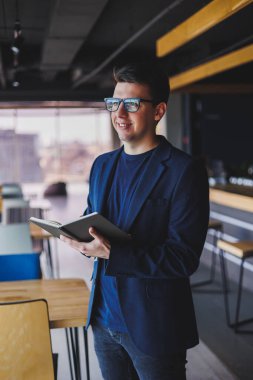 Kafede not defteriyle çalışan serbest çalışan genç bir adam, not defterli bir iş adamı, ceket ve gözlüklü bir adam.