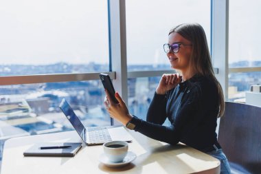 Kafeteryada bilgisayar ve kahve fotokopi alanı kullanarak çalışan mutlu Avrupalı kadın. Başarılı bayan serbest yazar dizüstü bilgisayarda yazıyor, uzaktan çalışıyor.