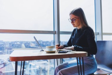 Kafeteryada bilgisayar ve kahve fotokopi alanı kullanarak çalışan mutlu Avrupalı kadın. Başarılı bayan serbest yazar dizüstü bilgisayarda yazıyor, uzaktan çalışıyor.