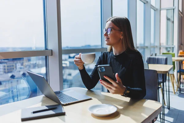 Kafeteryada bilgisayar ve kahve fotokopi alanı kullanarak çalışan mutlu Avrupalı kadın. Başarılı bayan serbest yazar dizüstü bilgisayarda yazıyor, uzaktan çalışıyor.