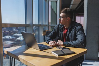 İşletme bilgisi, kurumsal para yatırım raporu, dizüstü bilgisayarlar ve dijital pazarlama üzerine çevrimiçi araştırma yaparken notlar yazan profesyonel yönetici.