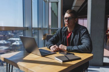 İşletme bilgisi, kurumsal para yatırım raporu, dizüstü bilgisayarlar ve dijital pazarlama üzerine çevrimiçi araştırma yaparken notlar yazan profesyonel yönetici.