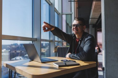 İşletme bilgisi, kurumsal para yatırım raporu, dizüstü bilgisayarlar ve dijital pazarlama üzerine çevrimiçi araştırma yaparken notlar yazan profesyonel yönetici.