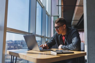 İşletme bilgisi, kurumsal para yatırım raporu, dizüstü bilgisayarlar ve dijital pazarlama üzerine çevrimiçi araştırma yaparken notlar yazan profesyonel yönetici.