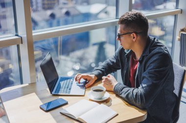 İşletme bilgisi, kurumsal para yatırım raporu, dizüstü bilgisayarlar ve dijital pazarlama üzerine çevrimiçi araştırma yaparken notlar yazan profesyonel yönetici.