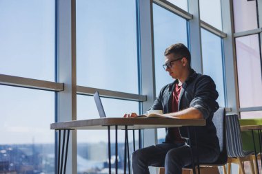 İşletme bilgisi, kurumsal para yatırım raporu, dizüstü bilgisayarlar ve dijital pazarlama üzerine çevrimiçi araştırma yaparken notlar yazan profesyonel yönetici.