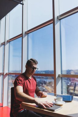 Akıllı yazılım geliştiricisi masaüstünde dizüstü bilgisayarla birlikte oturuyor ve serbest çalışma sırasında mesajlaşma ve ağ oluşturma için ağ kitabı kullanarak yayıncılık fikri yaratıyor.