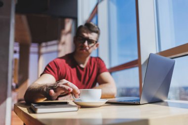 Akıllı yazılım geliştiricisi masaüstünde dizüstü bilgisayarla birlikte oturuyor ve serbest çalışma sırasında mesajlaşma ve ağ oluşturma için ağ kitabı kullanarak yayıncılık fikri yaratıyor.
