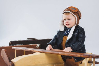 Çocuk deri bir ceket ve pilot şapkası içinde ağlıyordu. Tahta bir uçak, kahverengi bavullar. Çocukların tahta oyuncakları. Bebek duyguları