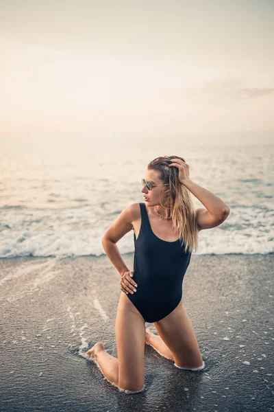 Aantrekkelijke Jonge Vrouw Met Een Zonnebril Knielt Zee Bij Zonsondergang — Stockfoto