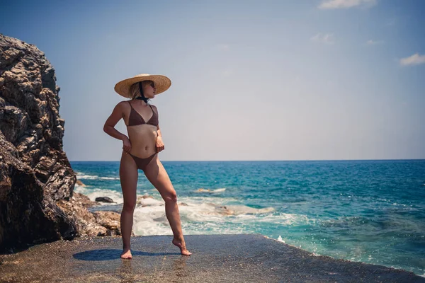 수영복을 모자를 아름다운 아가씨가 해변을 해변을 다닌다 — 스톡 사진