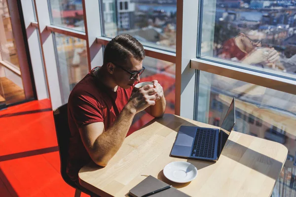 Akıllı yazılım geliştiricisi masaüstünde dizüstü bilgisayarla birlikte oturuyor ve serbest çalışma sırasında mesajlaşma ve ağ oluşturma için ağ kitabı kullanarak yayıncılık fikri yaratıyor.