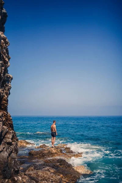 Ένας Νεαρός Άνδρας Στέκεται Στους Βράχους Θέα Την Ανοιχτή Μεσόγειο — Φωτογραφία Αρχείου