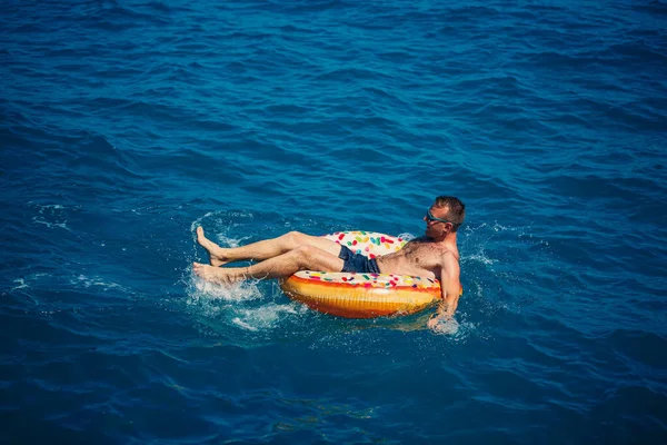 Ein Junger Mann Schwimmt Einem Sonnigen Tag Auf Einem Aufblasbaren — Stockfoto