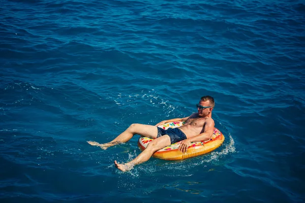 Ein Junger Mann Schwimmt Einem Sonnigen Tag Auf Einem Aufblasbaren — Stockfoto