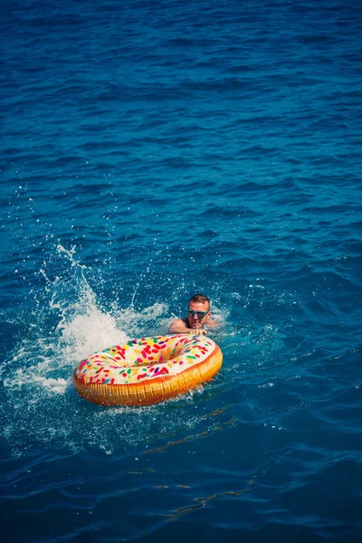 Ein Mann Schwimmt Auf Einem Aufblasbaren Ring Meer Mit Blauem — Stockfoto