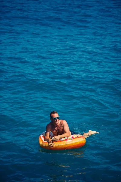 Νεαρός Άνδρας Ένα Φουσκωτό Δαχτυλίδι Στη Θάλασσα Ξεκουράζεται Και Κολυμπάει — Φωτογραφία Αρχείου