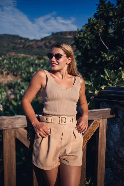 Genç ve güzel bir kadın yeşil koruluğun çarpıcı manzarasıyla gözlem güvertesinde duruyor. Yüksek kalite fotoğraf