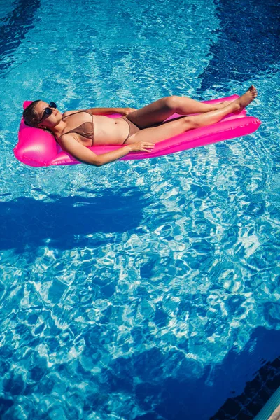 Havuzdaki Pembe Şişme Yatakta Mayo Giymiş Seksi Bir Kadın Yatıyor — Stok fotoğraf