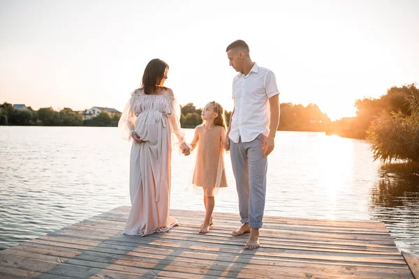 Hamile bir karısı ve kızı olan bir koca, gün batımında güneşli yaz günbatımında rıhtımda dinleniyor. Birbirine aşık çiftler el ele tutuşuyorlar. Mutlu bir aile.