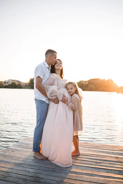 Hamile bir karısı ve kızı olan bir koca, gün batımında güneşli yaz günbatımında rıhtımda dinleniyor. Birbirine aşık çiftler el ele tutuşuyorlar. Mutlu bir aile.