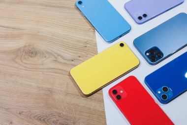 Çok renkli, modern telefonlar ile ayarlanmış. Cep telefonları açıklamalar için boşluk bırakarak masanın üzerinde uzanıyor..