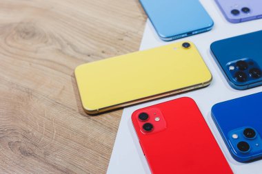 Çok renkli, modern telefonlar ile ayarlanmış. Cep telefonları açıklamalar için boşluk bırakarak masanın üzerinde uzanıyor..